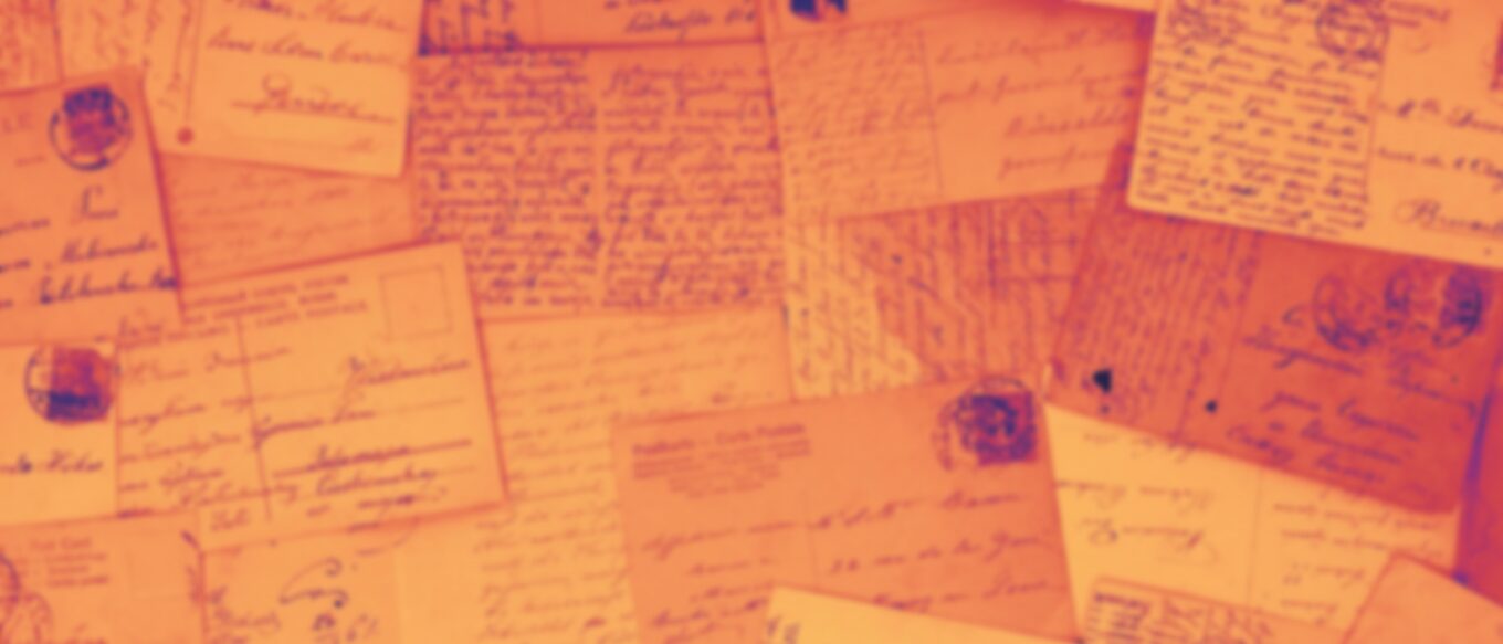 Letters and postcards lying with the text facing up, overlapping one another. They have been tinged an orange and some of the postmarks are purple-ish. The image has been blurred so the words are not visible.