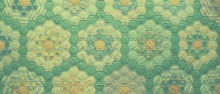 A quilt made up of small, hexagonal pieces of fabric that are sewn together to form larger hexagons. They are tinged green, but some pieces of fabric have patterns and are yellowish or pinkish in color.